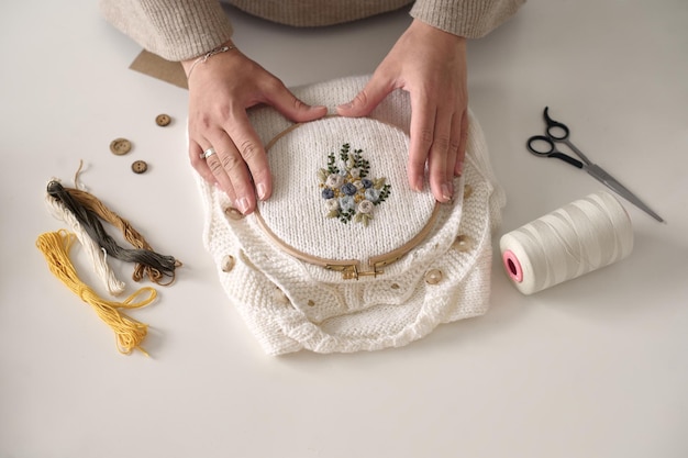 ręce trzymające haftowaną tkaninę